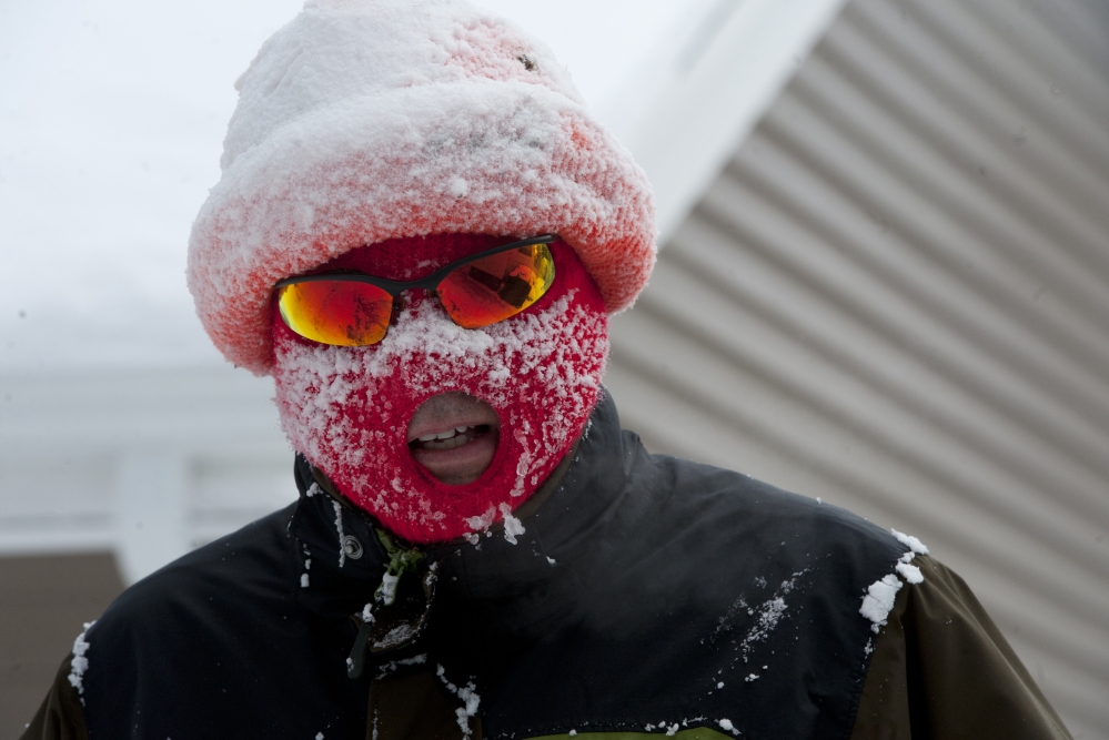 Anthony LaPorte of Jackson is covered in snow after snowblowing out his driveway and sidewalk on the northeast side Jackson, Mich., on Monday, Jan. 27, 2014. Gusting winds and blowing snow caused whiteout conditions Monday that made travel treacherous on some Michigan roadways, and hundreds of schools closed because of the severe weather.