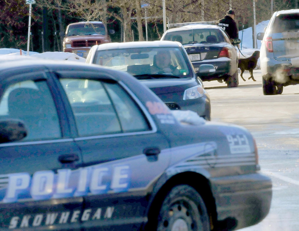 SEARCH: A police officer and a dog enter the Walmart store in Skowhegan shortly after a bomb threat was made on Tuesday.