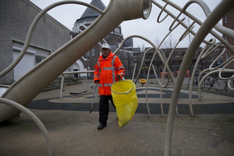 Ramon Mohamed Halim Smits, participant in a pilot project for alcoholics, cleans a playground in Amsterdam's eastern part Wednesday. The city has teamed up with a charity organization in hopes of improving the neighborhood and possibly improving life for the alcoholics. Participants are given beer in exchange for a little work collecting litter, eating a decent meal, and sticking to their schedule.