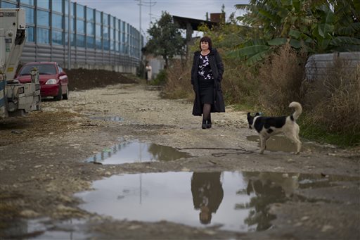 Irina Kharchenko walks in the yard of her house beside the screen separating the yard of her house and a federal highway in the village Vesyoloye outside Sochi, Russia.