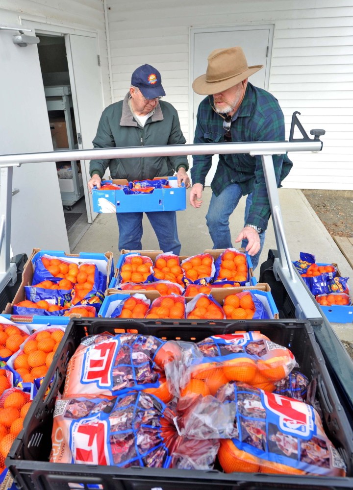 Donations: Dave Dawson, right, and Kerry Temple with the Waterville Area Food Bank unload cases of oranges at the United Methodist Church on Pleasant Street in Waterville on Friday.