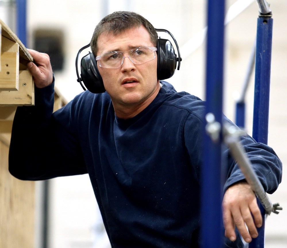 Press Herald photo by Gabe Souza LEARNING A TRADE: Travis Bentley works during a building construction class at Central Maine Community College in Auburn on Friday. Bentley is a graduate of Veterans Treatment Court.