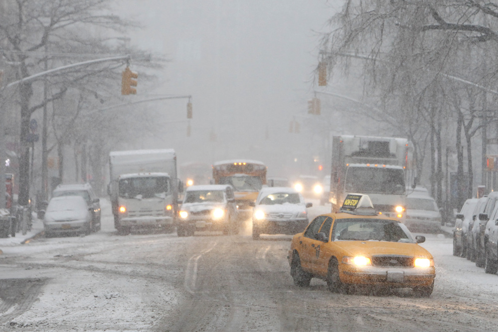 Traffic moves slowly down Hudson Street Monday in New York. After several days of mild weather, snow has returned to the Northeast.