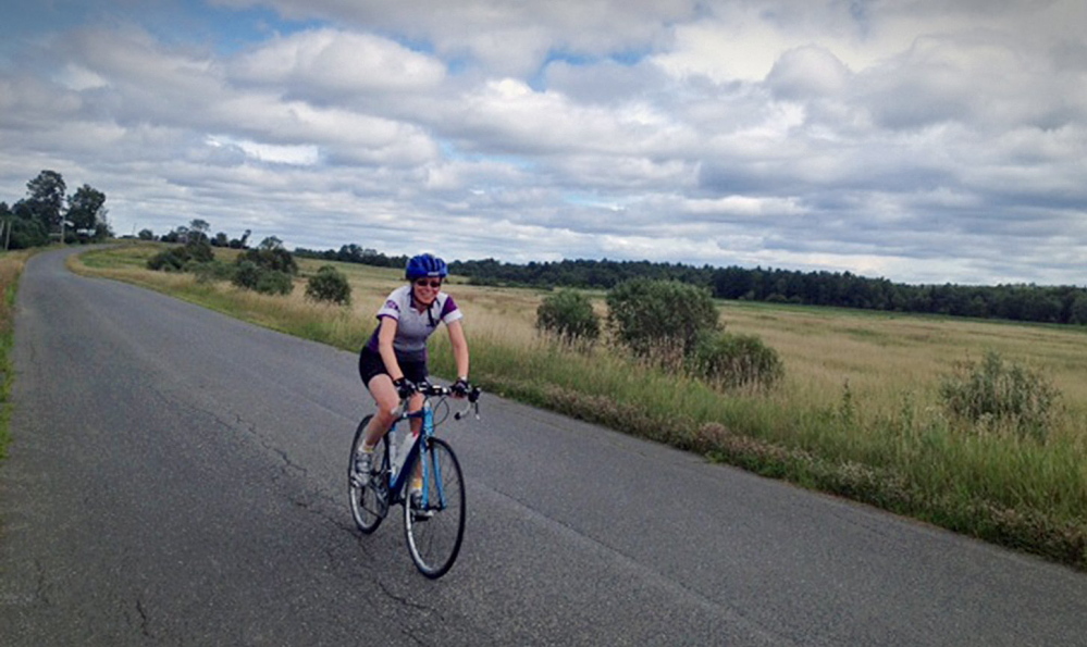 ON THE ROAD AGAIN: Kim True, ride director of the BikeMaine bicycle tour, rides along a stretch of last year’s course in this August 2013 photo.