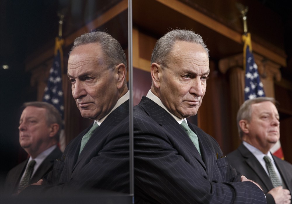 Sen. Charles Schumer, D-N.Y., the Democratic Policy Committee chairman, left, and Senate Majority Whip Richard Durbin of Illinois are reflected in a TV monitor as they talk to reporters about efforts pass a bill to extend unemployment benefits on Thursday during a news conference on Capitol Hill in Washington.
