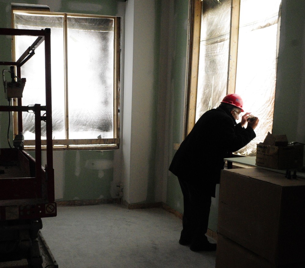 Courthouse progress: Maine Supreme Judicial Court Associate Justice Joseph Jabar looks through a hole in plastic window covering on Thursday during a tour of the new court building in Augusta to check out the view of the State House from the window of what will be his office.