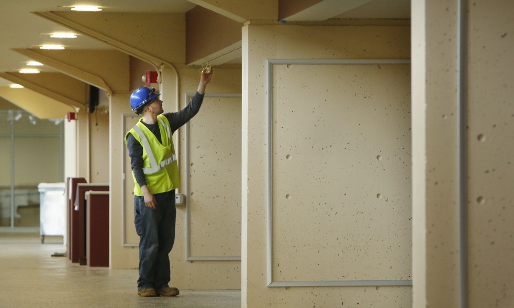 Joe Tipsword, who works for E.S. Boulos Co., installs a light at the Cumberland County Civic Center on Monday. The 15-month renovation is nearing its end as the civic center prepares to open for the 24th annual Maine Home, Remodeling and Garden Show this weekend.