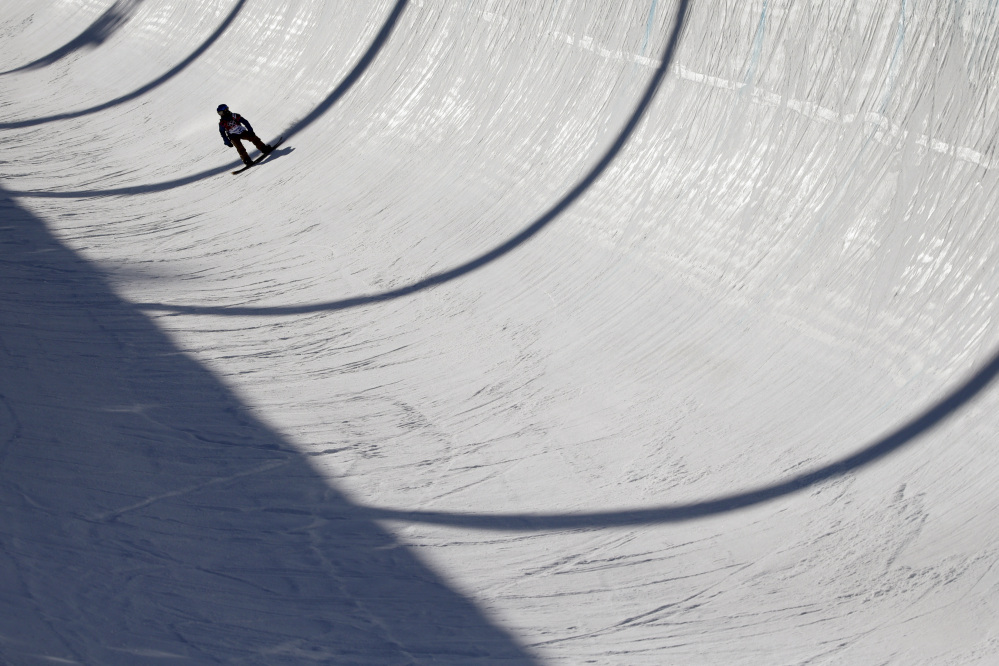 An athlete lands after a jump during a training session Saturday for the men’s snowboard halfpipe at the 2014 Winter Olympics. There were dozens of falls, very few big tricks and a lot of complaining during a practice session Monday that was pushed from morning to night