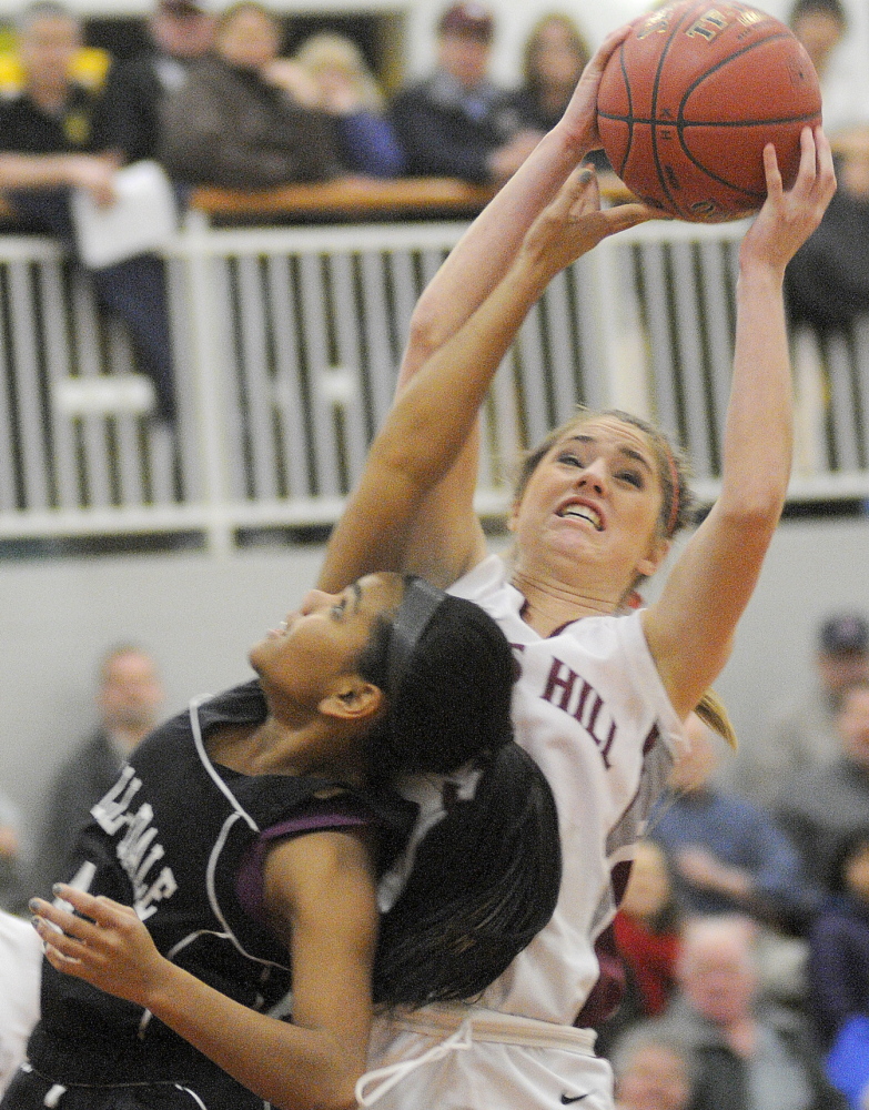 Staff photo by Andy Molloy OVER THE TOP: Kents Hill School’s Sara Grenier, right, grabs a rebound away from Hall-Dale High School’s Dani Sweet go for a ball during their Western C prelim match Tuesday in Readfield.
