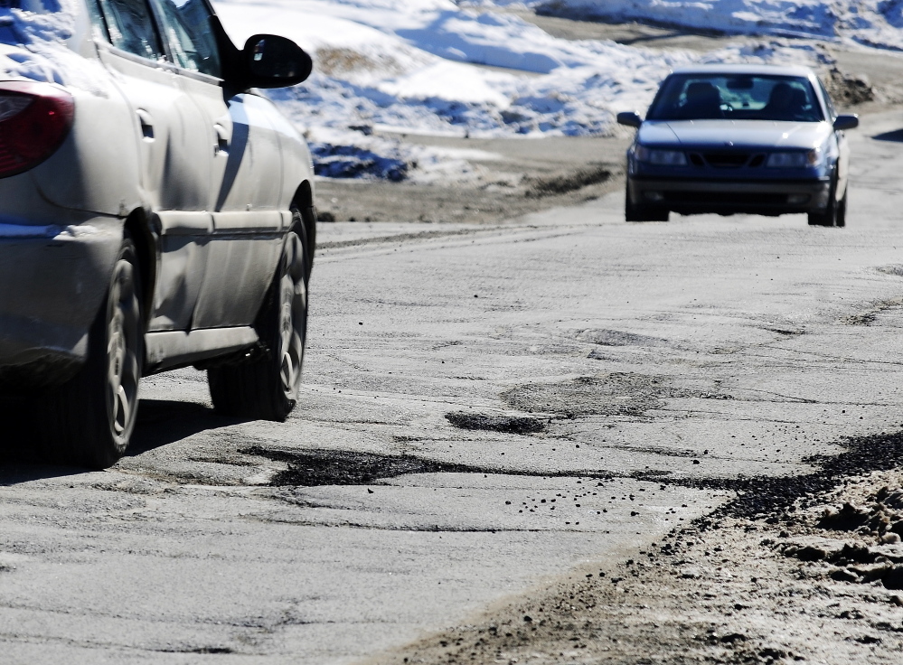 Staff photo by Joe Phelan Cars drive past cracked pavement and filled potholes on Mount Vernon Avenue on Tuesday February 11, 2014 in Augusta.