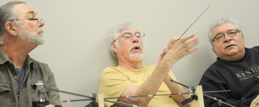 FLYING HIGH: Veterans Ron Carleton, left, Marc Bilodeau and Dwaine LaChance assemble a fly rod Wednesday at VA Maine Healthcare Systems-Togus during a meeting of Project Healing Waters. A dozen veterans worked together to build the rods under the supervision of volunteers.