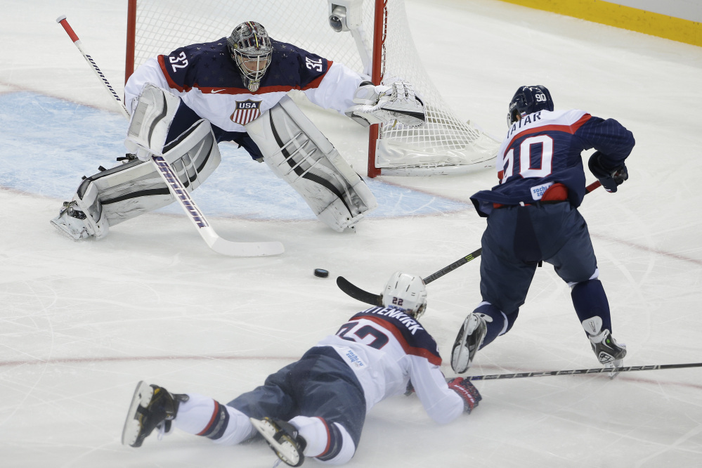 USA goaltender Jonathan Quick defends his goal against Slovakia forward Tomas Tatar as =22= slides across the ice during the 2014 Winter Olympics men’s ice hockey game at Shayba Arena, Thursday, Feb. 13, 2014, in Sochi, Russia.