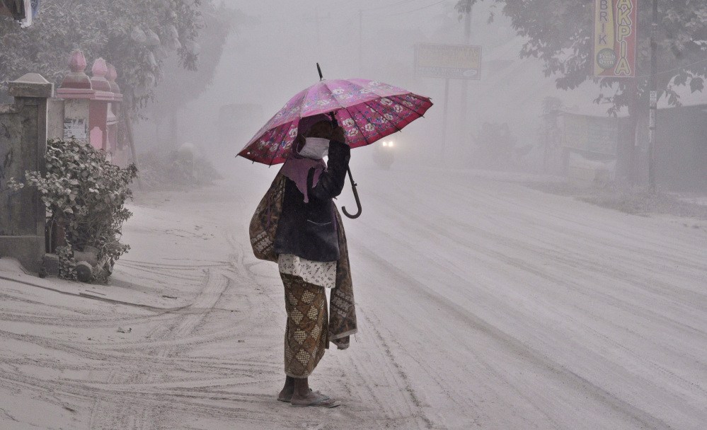 A woman walks on a road covered with volcanic ash in Yogyakarta, Indonesia, following an eruption of Mount Kelud Friday.