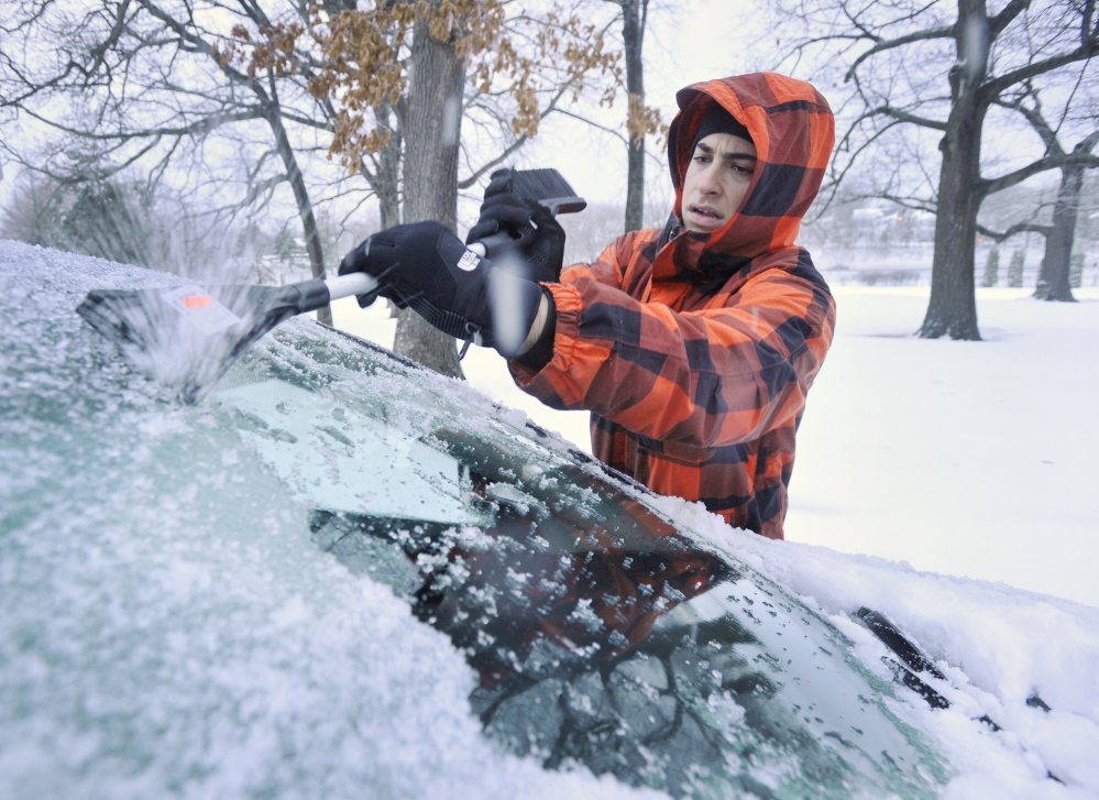 Mitchell Mamorsky, a University of New England Dental School student from Brooklyn, N.Y., scrapes ice Friday from his car, which he parked overnight in Portland’s Deering Oaks.