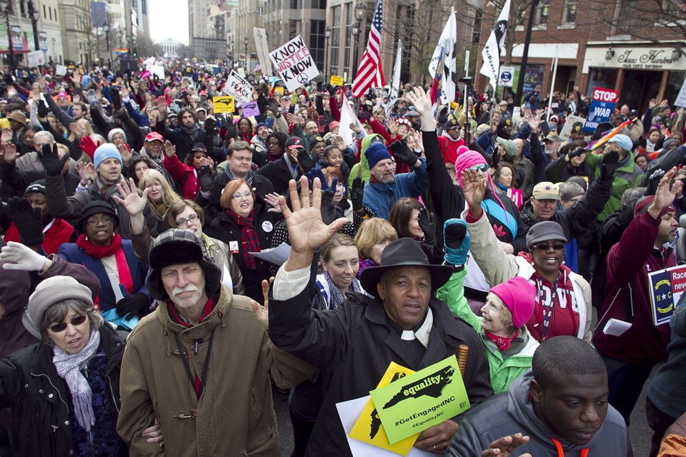 Rev. Jerry Dowdy of Carthage, N.C., sings with thousands of others during a march in Raleigh, N.C. Saturday Feb. 8, 2014. Nearly 200 organizations are joining the National Association for the Advancement of Colored People in the "Moral March on Raleigh," a new name for the "Historic Thousands on Jones Street," as it was originally called. Jones Street referred to the street where the Legislative Building stands and the usual terminus of the march. Advocates are angry about bills Gov. Pat McCrory has signed into law, including the refusal to expand Medicaid under the federal health care law; a reduction in unemployment benefits; an elections-overhaul law that requires photo identification to vote in person; the elimination of the earned income tax credit; and taxpayer-funded grants for low-income children to attend private K-12 schools. (AP Photo/The News & Observer, Robert Willett)