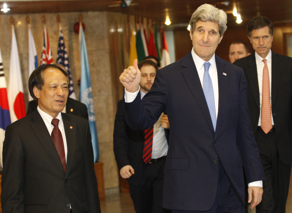 U.S. Secretary of State John Kerry, right, waves to the press after meeting with Secretary-General of Association of Southeast Asian Nations (ASEAN), Le Luong Minh , left, at the ASEAN headquarters in Jakarta, Indonesia on Sunday.