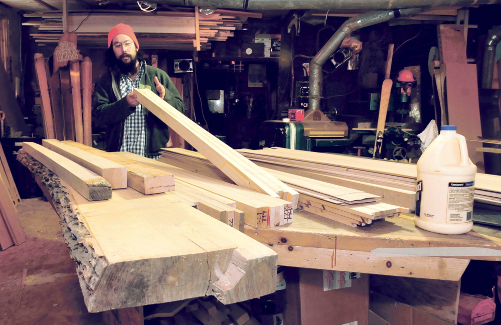 STEP ONE: Nick Mukai looks over raw stock of local ash and basswood that will be used to make a pair of custom wood skies at the Lucid Ski business in Phillips on Thursday, Feb. 13, 2014.
