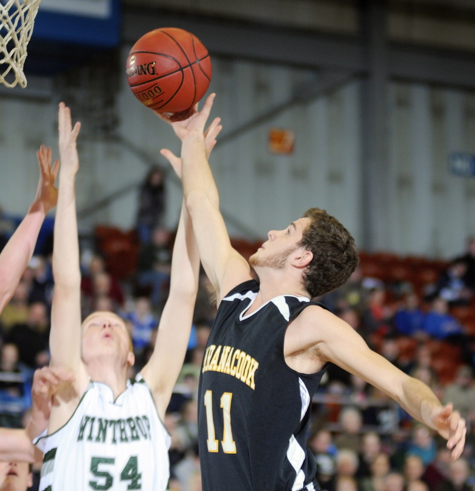 GETTING AFTER IT: Maranacook Community School senior guard Taylor Wilbur, right grabs a rebound in front of Winthrop High School sophomore center Anthony Owens during a Western Class C quarterfinal game Monday in Augusta Civic Center. The Black Bears play Waynflete Saturday for the Western Class C championship.