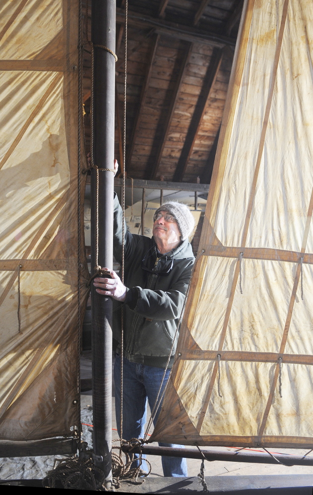 FULL SAILS: Larry Buggia adjusts the mast on the ice boat that was re-assembled on the second floor of the carriage house at the Monmouth Museum. Buggia and other members of the Museum volunteered their time to build the sled that was constructed and raced on Cobbossee Lake in the early 20th Century.