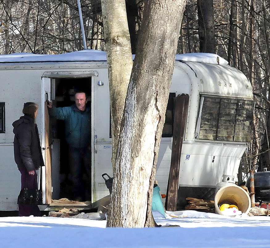 HOMELESS: Homeowner Ken Whitt speaks to a friend on Tuesday from inside a recreational vehicle hours after fire destroyed his mobile home in Clinton. Whitt said he plans to rebuild.