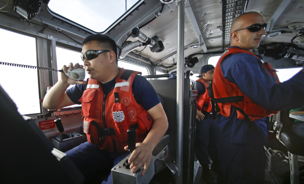 This photo taken Jan. 28, 2014, Coast Guard officer William Pless communicates on the radio while steering the 45 foot Coast Guard vessel through a dense fog during a patrol off the San Diego coast in San Diego.