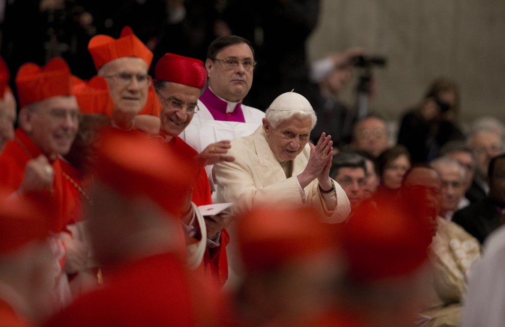 Pope Emeritus Benedict XVI waves as he attends a consistory inside St. Peter’s Basilica at the Vatican on Saturday. Benedict XVI joined Pope Francis in a ceremony creating the cardinals who will elect their successor in an unprecedented blending of papacies past, present and future.