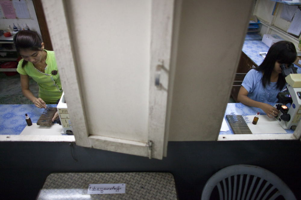 Laboratory workers sort tuberculosis test samples at a clinic for transmittable diseases funded by Doctors Without Borders on the outskirts of Yangon, Myanmar. The organization has been expelled from the country.