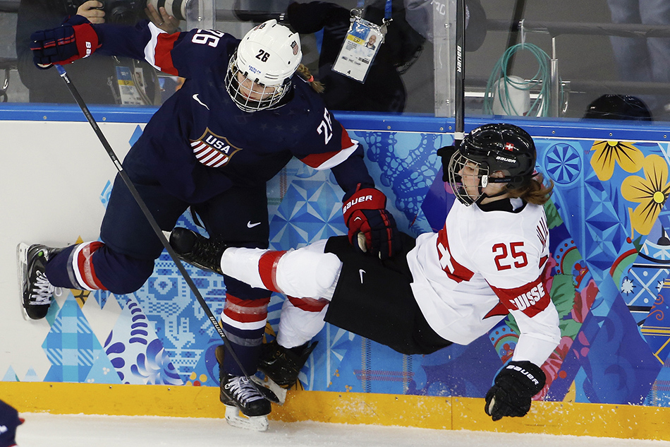 Kendall Coyne of the Untied States collides with Alina Muller of Switzerland against the boards during the first period of the 2014 Winter Olympics women's ice hockey game at Shayba Arena, Monday, Feb. 10, 2014, in Sochi, Russia. (AP Photo/Petr David Josek) 2014 Sochi Olympic Games;Winter Olympic games;Olympic games;Spor