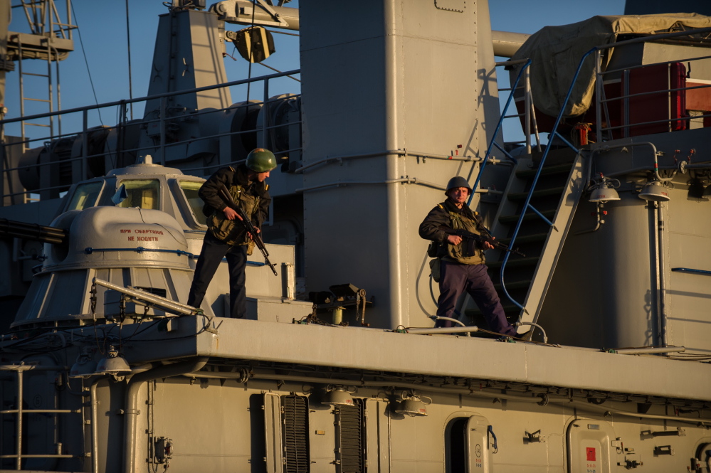 Ukrainian seamen stand guard on the Ukrainian navy ship Slavutich in the harbor of Sevastopol, Ukraine, on Monday. The Ukrainian Defense Ministry said Russian forces that have overtaken Ukraine’s strategic region of Crimea are demanding that the ship’s crew surrender.