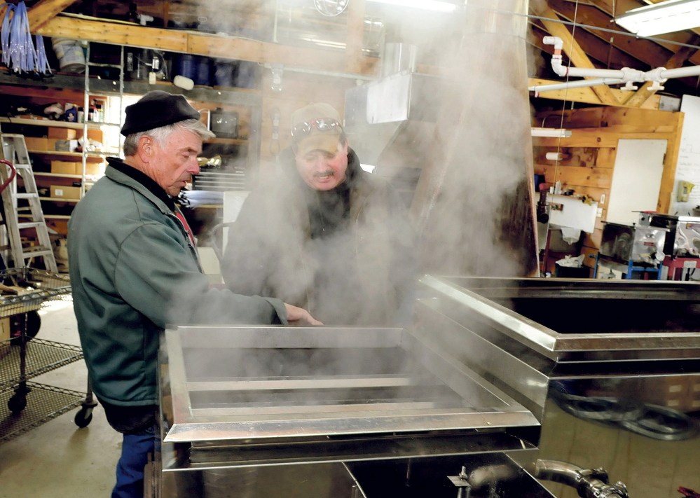 BOILING READY: Bob Bacon, left, of the Bacon Farm in Sidney, speaks with Jim Wright of Apple Ridge maple syrup operation in Cornville as steam rises from a sap evaporator in Sidney on Monday, March 3, 2014. Bacon said it was the second time he boiled syrup this season and expects his operation to increase this weekend as temperatures rise.