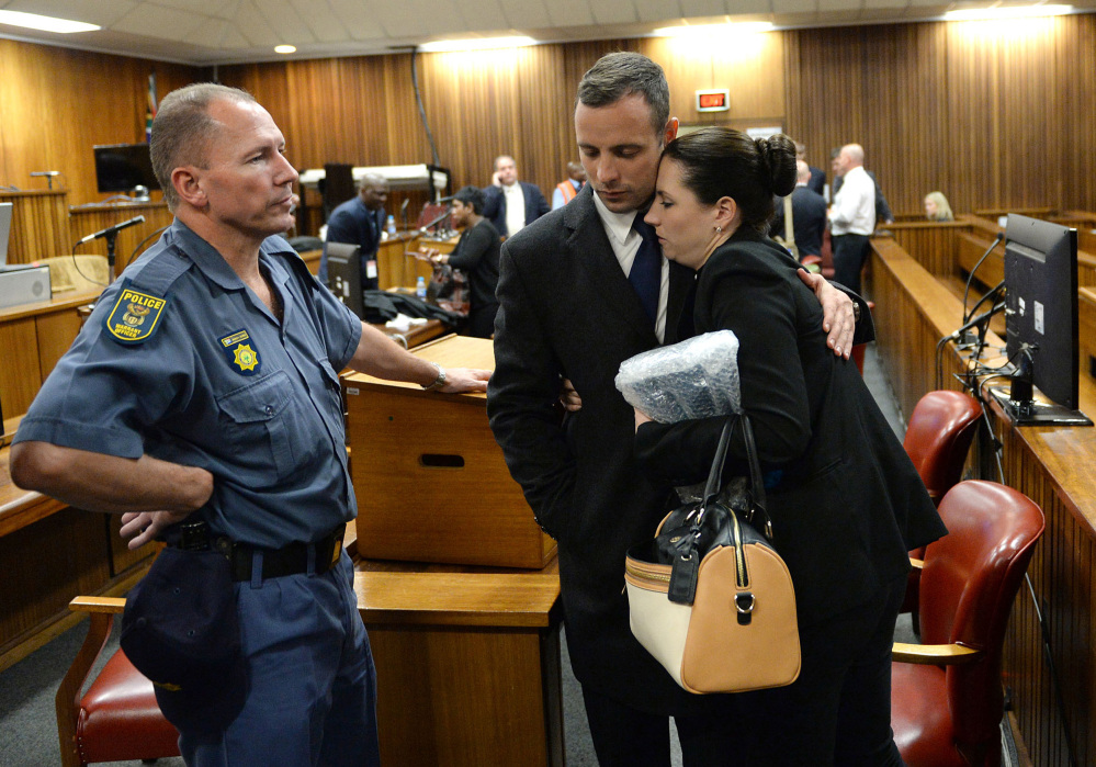 Oscar Pistorius hugs his sister, Aimee, inside court at the end of the second day of his trial at the high court in Pretoria, South Africa, on Tuesday. Pistorius is charged with murder in the shooting death of his girlfriend, Reeva Steenkamp, on Valentines Day in 2013.