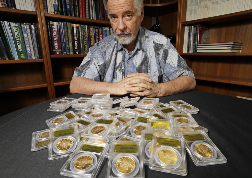 David Hall, co-founder of Professional Coin Grading Service, poses with some of 1,427 Gold Rush-era U.S. gold coins, at his office in Santa Ana, Calif. A California couple out walking their dog on their property stumbled across the bonanza.