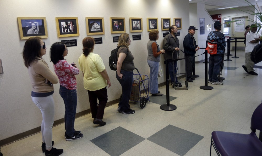 People line up at the food pantry at Sacred Heart Community Service recently in San Jose, Calif., where homelessness and racial disparities are on the rise.