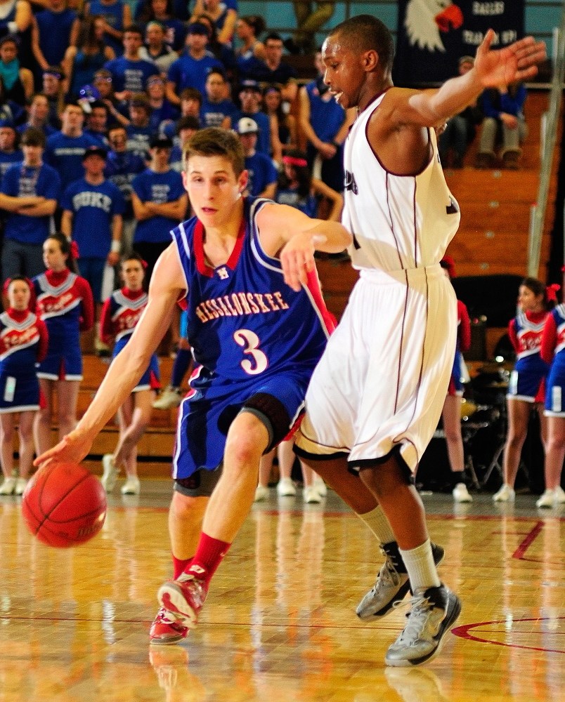 Staff photo by Joe Phelan Messalonskee's Jordan Holmes, left, dribbles past Edward Little's Mahad Mohamed during an Eastern Class A tournament game on Saturday February 16, 2013 at the Augusta Civic Center.