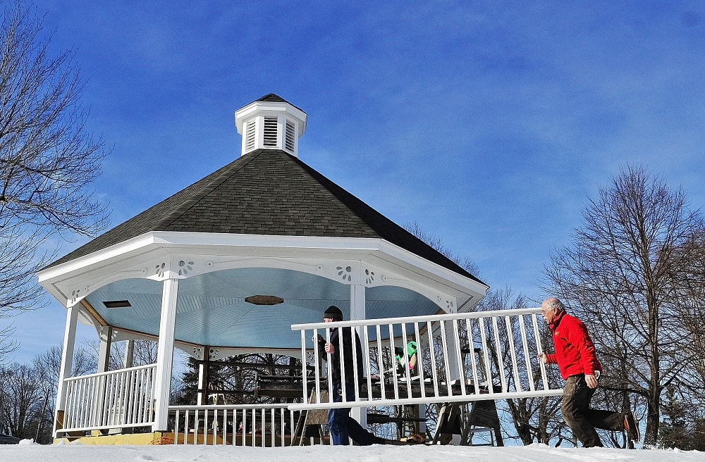 NEARING COMPLETION: David Mansir, left, and Joe Caputo carry another railing section into place on Friday as they work on the gazebo on the Gardiner Common.