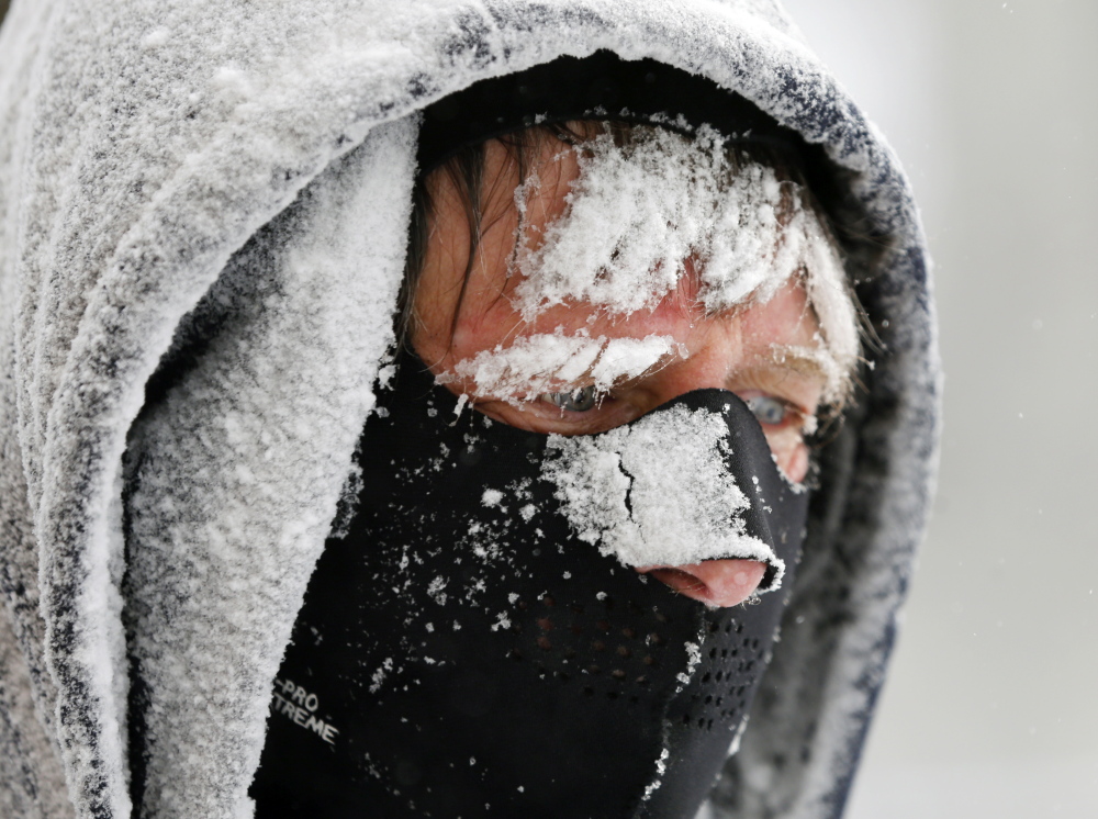 Bob Landon blows snow from a sidewalk in the South End neighborhood on Thursday in Albany, N.Y. Bitter cold temperatures return after a winter storm dumped up to 6 inches of snow and ice.