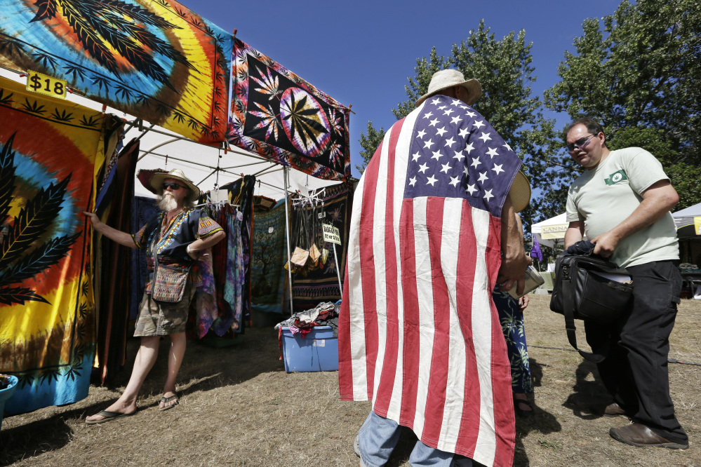 This is an Aug. 16, 2013, photo, showing the scene on the first day of Hempfest in Seattle. Those who have received the first legal pot licenses in Washington state have done so without going through a national background check.