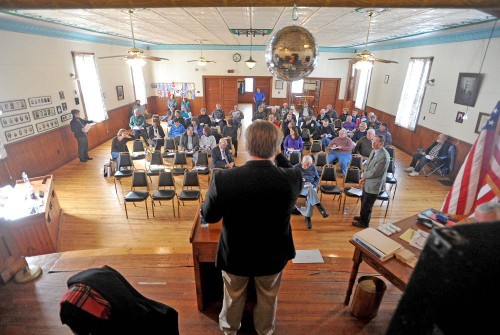 Town business: Dave Brenier, standing in the foreground, moderates the Town Meeting on Saturday at the Benton Grange.