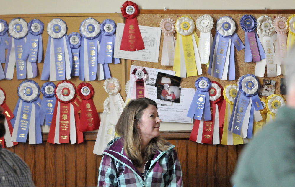 Listening: Lori Morin sits in front of a wall of ribbons Saturday while attending the Benton Town Meeting at the Benton Grange.