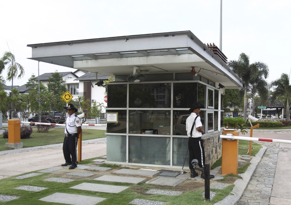 Security guards stand at a main gate of missing Malaysia Airlines pilot Zaharie Ahmad Shah’s house in Shah Alam, outside Kuala Lumpur on Saturday. Malaysian police have already said they are looking at the psychological state, the family life and connections of pilot Zaharie, 53, and co-pilot Fariq Abdul Hamid, 27. Both have been described as respectable, community-minded men.