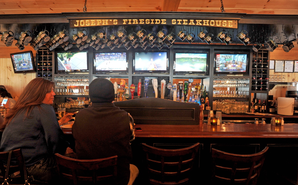 GOOD WINTER: A couple sits at the bar at Joseph’s Fireside Steakhouse on River Road in Waterville on Friday. Overall statewide revenues were down for the restaurant industry but local restaurants didn’t feel the squeeze as much.