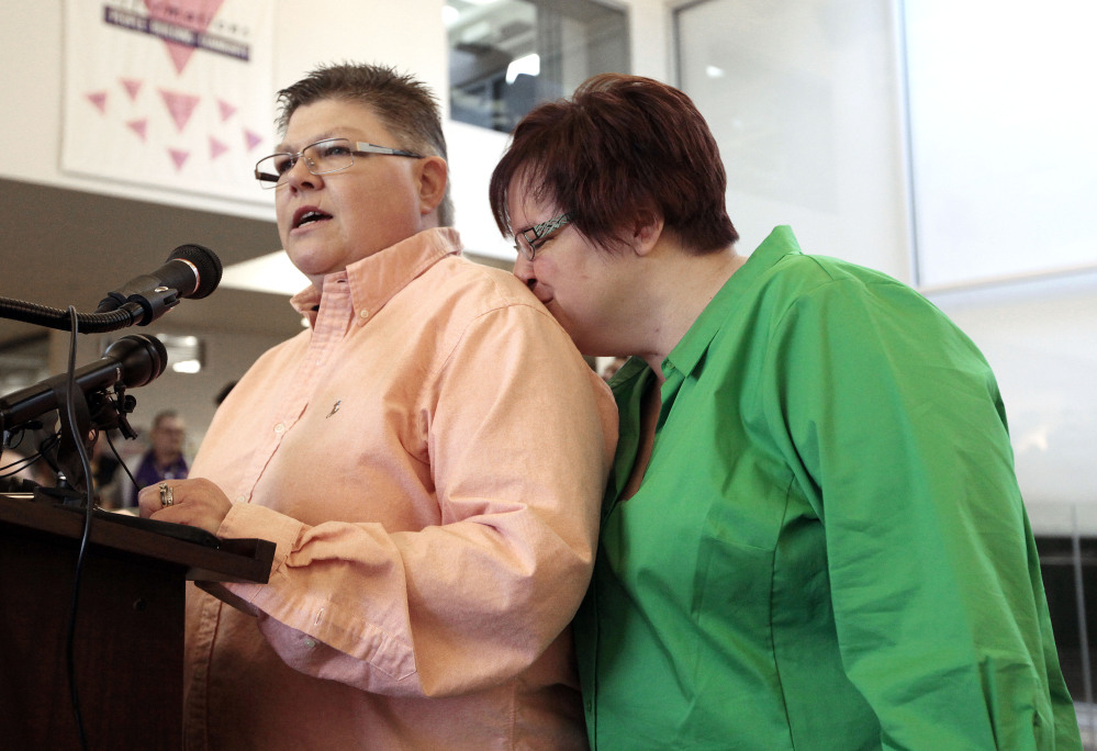 Jayne Rowse, left, speaks as April DeBoer, kisses her during a news conference in Ferndale, Mich., on Friday. A federal judge has struck down Michigan’s ban on gay marriage Friday the latest in a series of decisions overturning similar laws across the U.S. The two nurses who’ve been partners for eight years claimed the ban violated their rights under the U.S. Constitution.