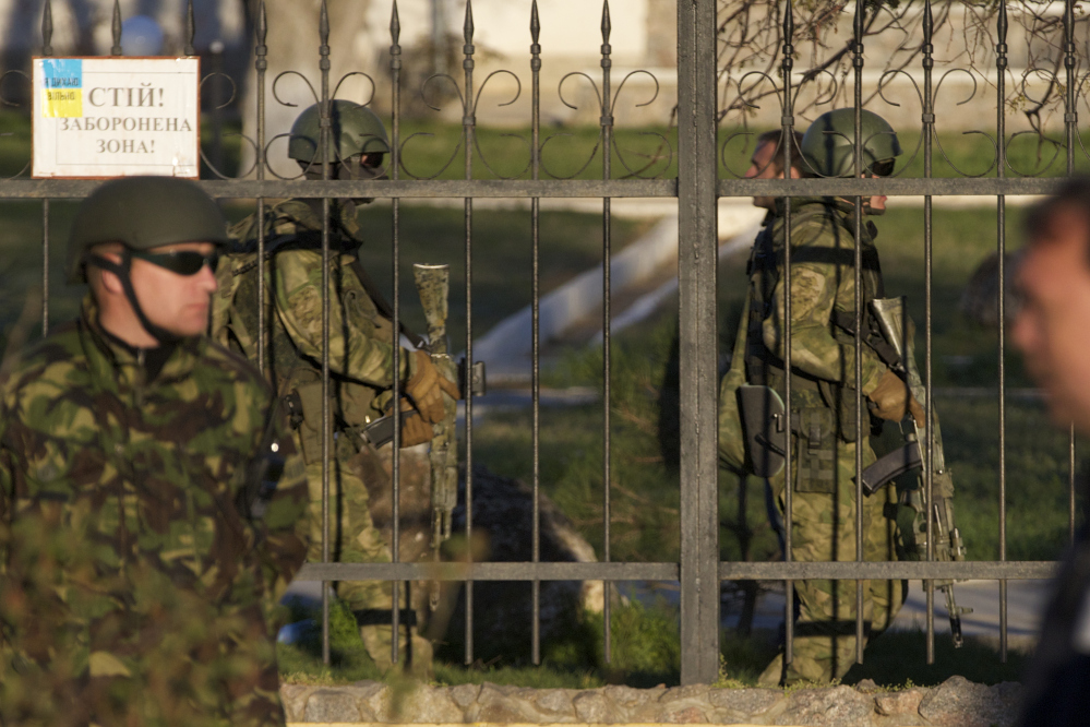 Russian soldiers walk inside the Belbek airbase, outside Sevastopol, Crimea, on Saturday. Russian forces used at least four armored vehicles to break into an air base here, seizing control of one of the last Ukrainian military outposts in Crimea. After an hours-long tense standoff between Russian and Ukrainian forces, gunfire and explosions could be heard as the vehicles broke down the gate at the air base located just outside Sevastopol.