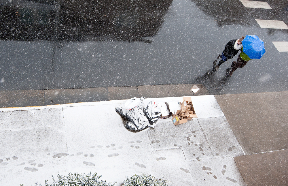 Snow falls as pedestrians cross the street Tuesday in Harrisonburg, Va. The National Weather Service says a powerful low-pressure system will develop off the mid-Atlantic coast Tuesday night.