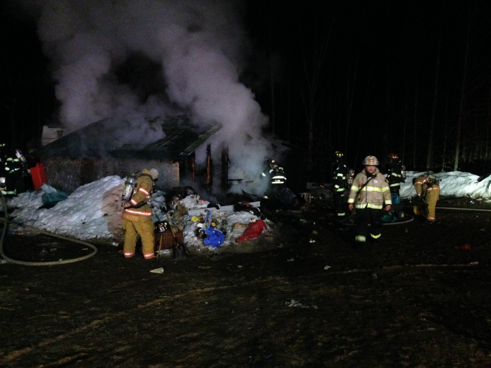 Firefighters secure the scene at a house fire Wednesday in New Gloucester, where four children and two adults managed to escape without injury.
