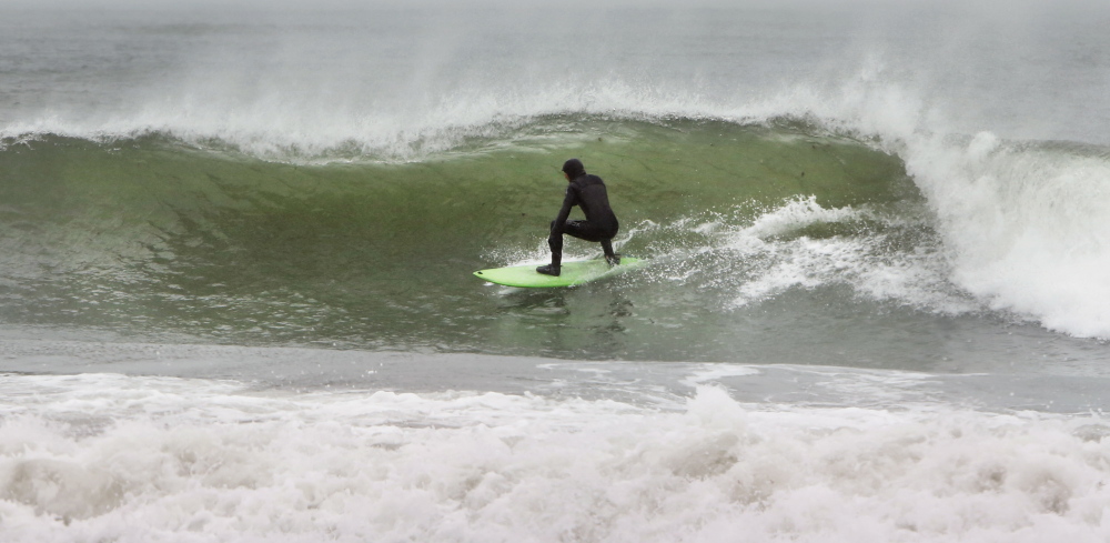 KENNEBUNK, ME - MARCH 30 A surfer takes advantage of waves kicked up by a combination of an astronomical high tide and strong northeast winds on Sunday, March 30, 2014 at Gooches Beach in Kennebunk. (Photo by Gregory Rec/Portland Press Herald)