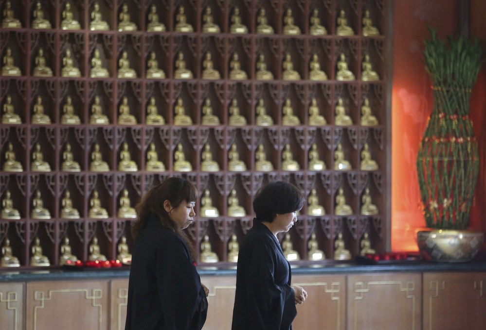 Chinese relatives of passengers on board the missing Malaysia Airlines Flight MH370 walk together after praying at a Buddhist temple in Petaling Jaya, Malaysia, Monday March 31, 2014. Relatives from China are in the country to seek answers of what happened to their loved one on board the plane.