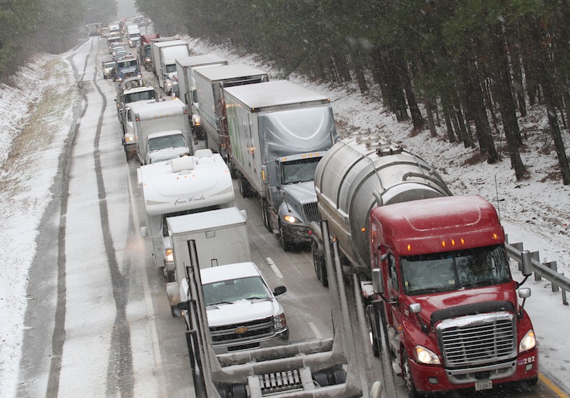 Motorists are at a standstill as emergency responders cleaned up a tractor-trailer wreck on Interstate 85 southbound near the Dinwiddie, Va. exit Monday, March 3, 2014. Winter kept its icy hold on much of the country Monday, with snow falling and temperatures dropping as schools and offices closed and people from the South and Mid-Atlantic to Northeast reluctantly waited out another storm indoors.