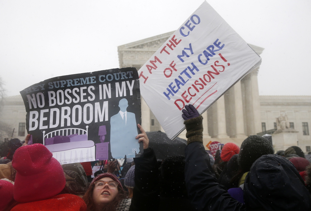 Demontrators gather in front of the Supreme Court in Washington last month as the court heard oral argument in the challenges of President Barack Obama’s health care law requirement that businesses provide their female employees with health insurance that includes access to contraceptives. The Associated Press
