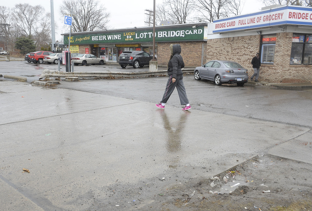 Cars enter local business at the scene of an attack on Wednesday at the street corners of Morang and Balfour on Thursday, April 3, 2014 in Detroit. A suburban Detroit man was in critical condition Thursday with severe head injuries after a neighborhood mob beat and kicked him when he stopped to check on a 10-year-old boy who stepped from a curb into the path of his pickup.